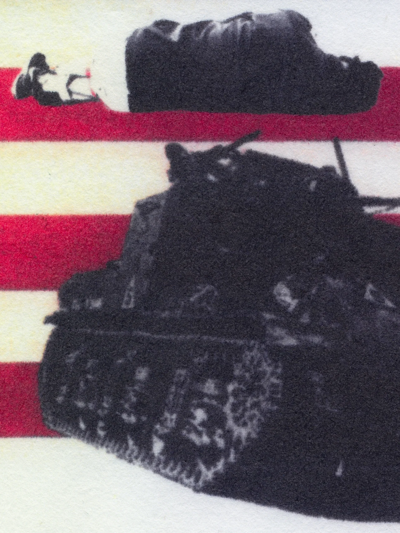 Assembly Line, 2025, by in vivo. Detail: a tank on the stripes with a person lying under a blanket above it.