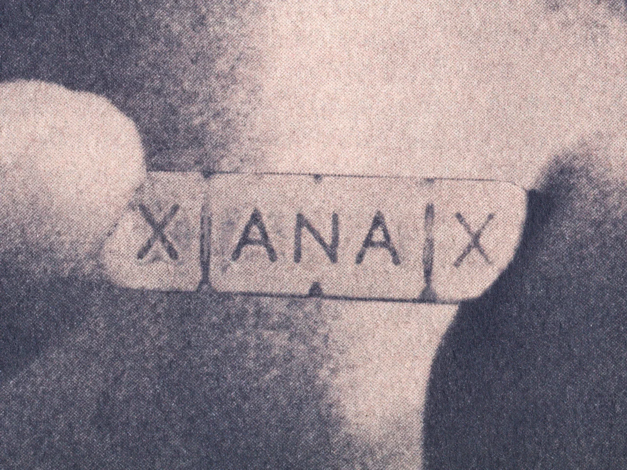 Ephemera, 2025, by in vivo. Detail: the Xanax bar between two fingertips.